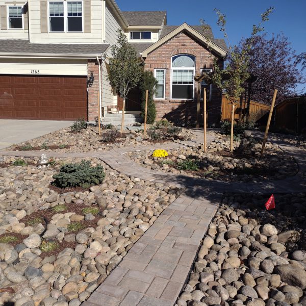 brown and yellow house with xeriscape garden, rocks and path