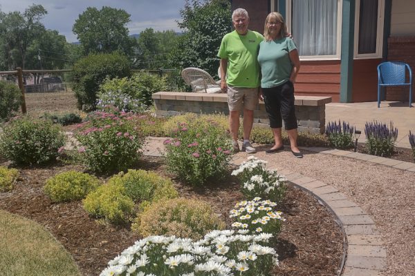 white flowers, garden path, happy couple standing near house